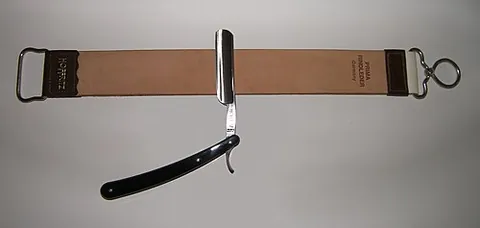 razor strop: a broad, heavy leather strop, designed to whet a razor on