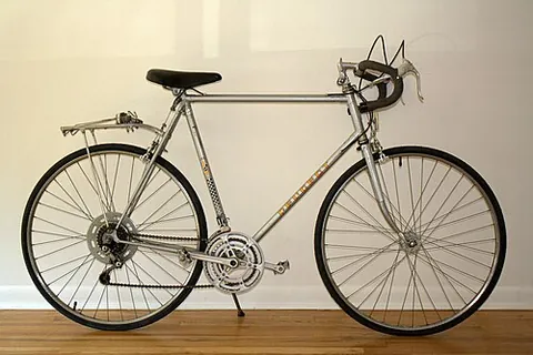road bike: a lightweight bicycle with narrow wheels and downward curving handlebars