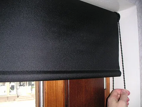 roller blind: a blind for a window, usually of stiffened fabric or vinyl, mounted on a pole and operated with a...