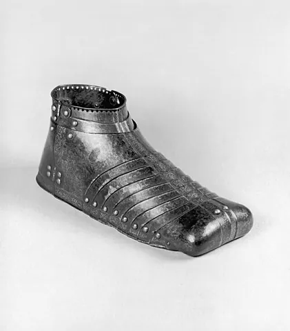 sabaton: a medieval armour covering for the foot, typically made of steel; a flexible armour shoe