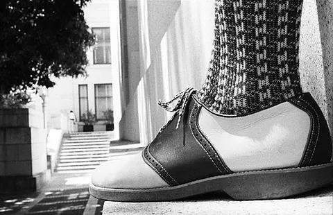 saddle shoe: a shoe, resembling an oxford, which has a saddle of a leather or colour different from the rest of...