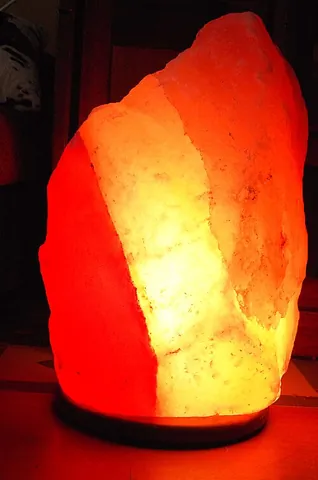 salt lamp: a lamp that radiates a pink or orange hue, made by placing a light source inside a hollow block of...