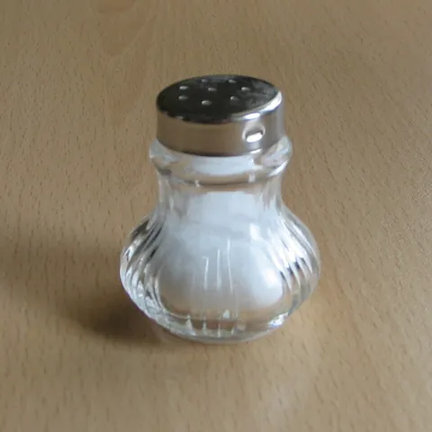 salt shaker: a small container designed to hold salt and facilitate sprinkling it on food for seasoning purposes