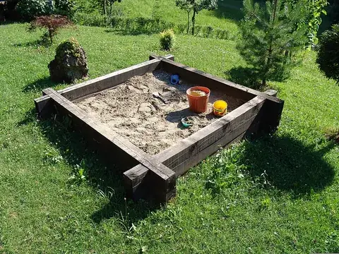 sandbox: a children's play area consisting of a box filled with sand