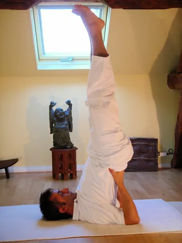 sarvangasana: a yoga pose in which the legs and pointed upwards and the lower body is lifted so that the weight...