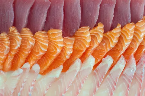 sashimi: a dish consisting of thin slices or pieces of raw fish or meat