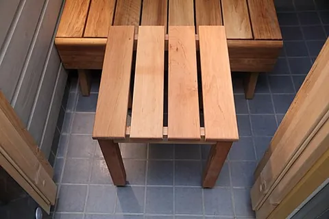 sauna stool: a low stool used for sitting while washing in a sauna or as a step to get up to the sauna benches