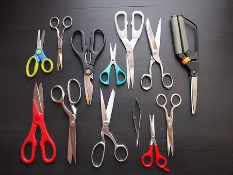 scissors: a tool used for cutting thin material, consisting of two crossing blades attached at a pivot point...
