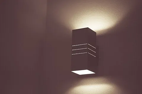 sconce: a fixture for a light, which holds it and provides a screen against wind or against a naked flame...