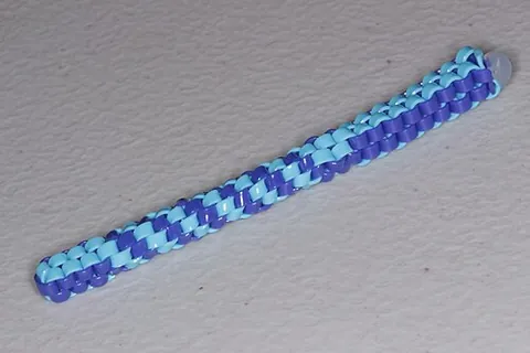 scoubidou: a plait woven from multi-coloured strips of coloured plastic