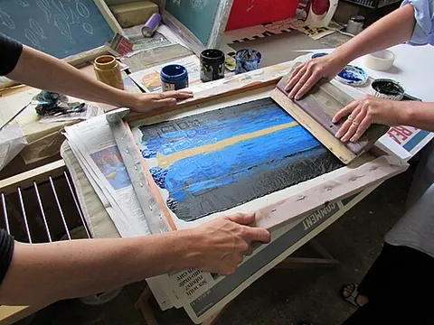 screen printing: a printing technique in which ink is forced through a woven mesh with an ink-blocking stencil on it