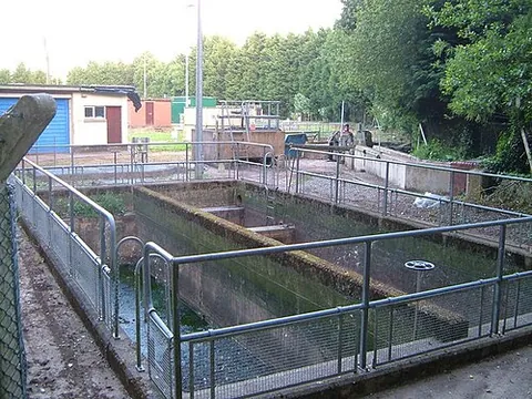 settlement tank: a container in which sediment or other denser materials in water settle on the bottom