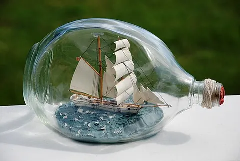 ship in a bottle: an ornament consisting of a model ship inside a glass bottle, usually one with a narrow neck which...