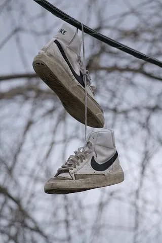 shoefiti: a pair of laced shoes thrown across raised cables or trees