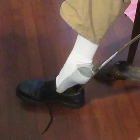 shoehorn: a smooth tool that assists in putting the foot into a shoe, by sliding the heel in after the toe is...