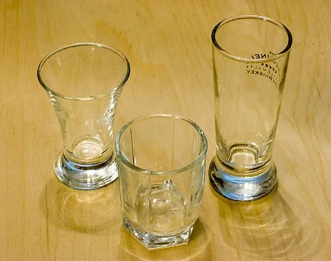 shot glass: a small glass used to hold or measure a small quantity of liquor