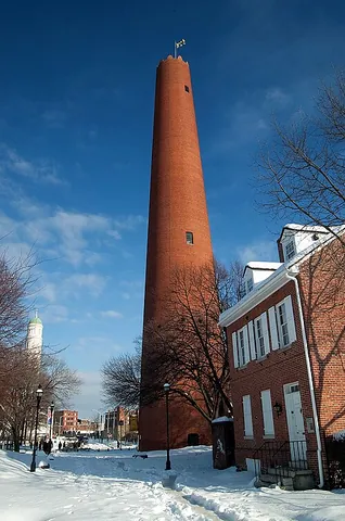 shot tower: a tall building in which droplets of molten lead fall into a pool of water in order to form lead...