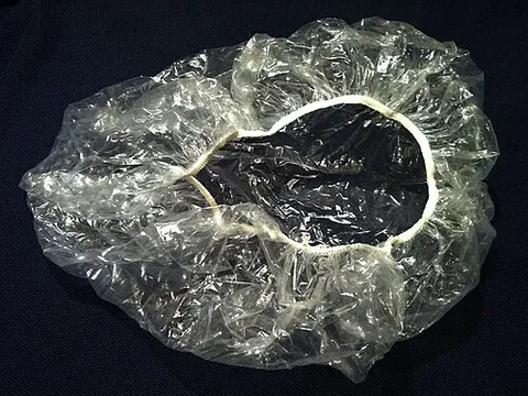 shower cap: a waterproof headgear designed for use in the shower, to avoid wetting the hair