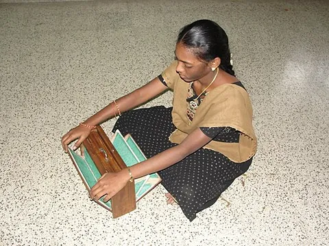 shruti box: a musical instrument resembling a harmonium, used to provide a droning accompaniment in Indian...