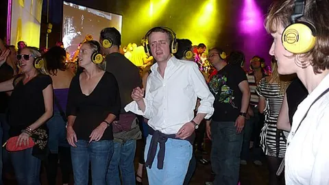 silent disco: an event at which people dance to music that is transmitted through wireless headphones rather than...