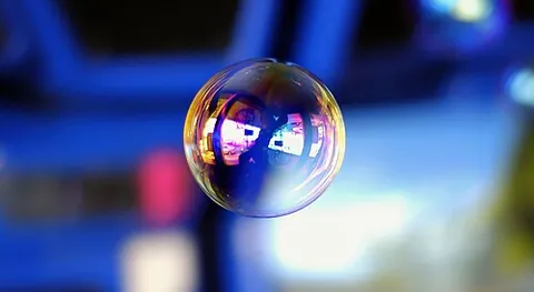 soap bubble: a very thin film of soapy water that forms a sphere with an iridescent surface