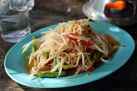 som tam: green papaya salad, a Thai dish of sliced sour fruits and vegetables, as green papayas, tomatoes,...