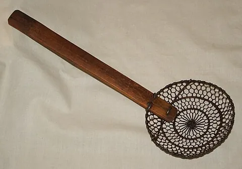 spider skimmer: a kitchen utensil, in the form of a wide shallow wire-mesh basket with a long handle, used for...