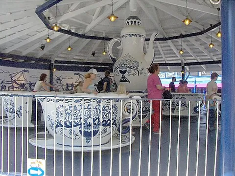 spinning teacups: an amusement ride consisting of a series of large spinning vehicles, shaped and decorated as giant...