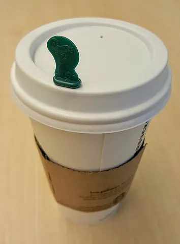 splash stick: a device used to keep heat and liquid from escaping a lidded cup. Introduced by Starbucks in Canada...