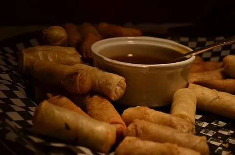 spring roll: a type of savoury food consisting of shredded vegetables wrapped in a pancake made from rice flour...