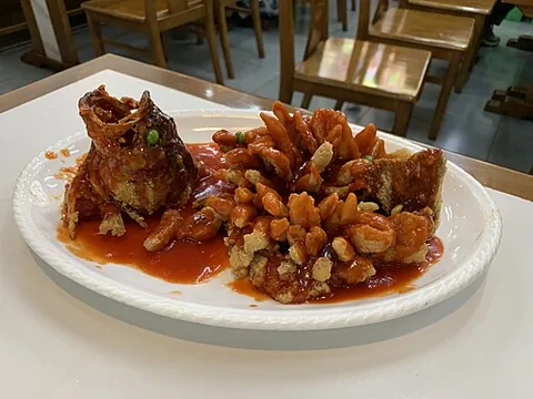squirrel fish: a Chinese dish of mandarin fish deboned and carved into an ornamental shape similar to a squirrel,...