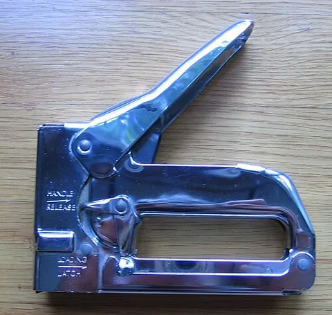 staple gun: a heavy-duty device for driving staples directly into wood or other material