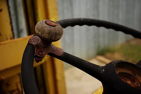 steering wheel spinner knob: a doorknob-shaped handle that attaches to the steering wheel of a vehicle to facilitate steering...
