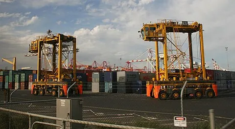 straddle carrier: a vehicle used in ports and yards for stacking and moving freight containers