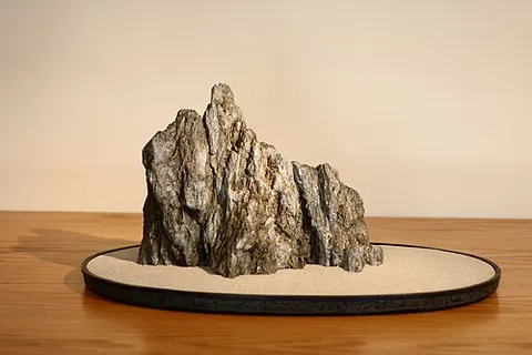 suiseki: a Japanese artform in which attractively shaped rocks and stones are mounted and displayed