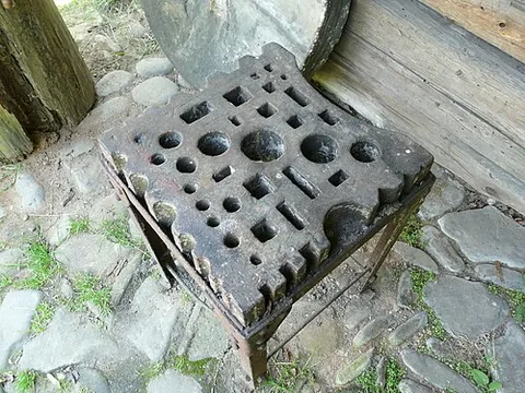 swage block: a perforated iron block with grooved sides and variously-sized holes in its face, used to hold in...