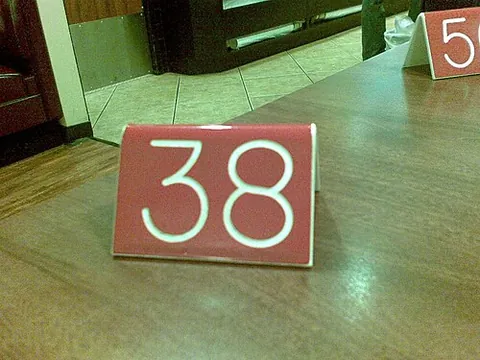 table tent: a sign made from card etc. folded into a triangular shape so that it can stand upright on a table
