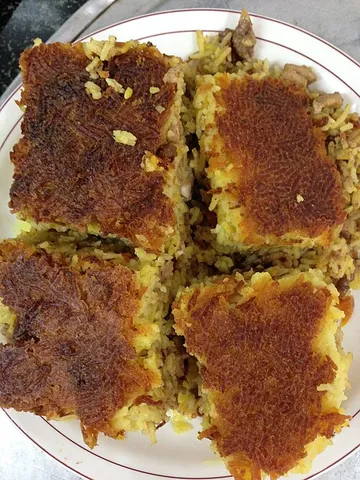 tahdig: the crispy layer of rice (and sometimes lavash bread, thinly sliced potatoes, egg or another...
