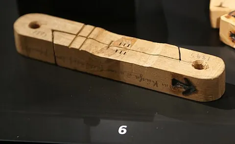 tally stick: a bone, or piece of wood, on which notches or scores are cut, as the marks of number, for account...