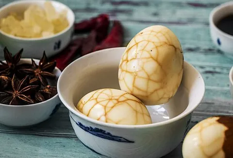 tea egg: an Asian snack consisting of a boiled egg that is cracked and then boiled again in tea