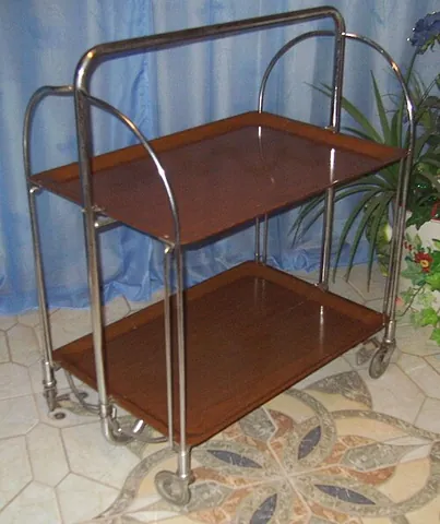 tea trolley: a table on wheels used to take food or drinks from the kitchen to the dining-room, or throughout a...