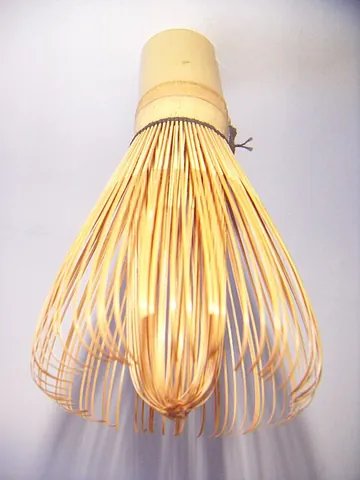 tea whisk: a kitchen utensil shaped and used like a shaving brush but typically made of bamboo rather than...
