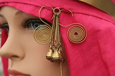 temple ring: a ring-shaped ornament that hangs from a headdress or in braids of hair near a person's temple...