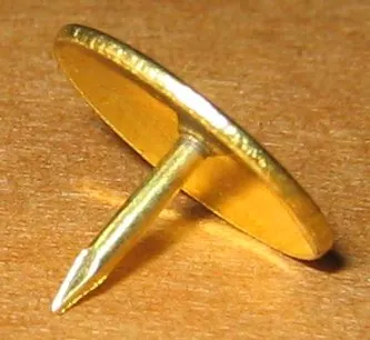 thumbtack: a small nail-like tack with a slightly rounded head that can be pressed into place with light...