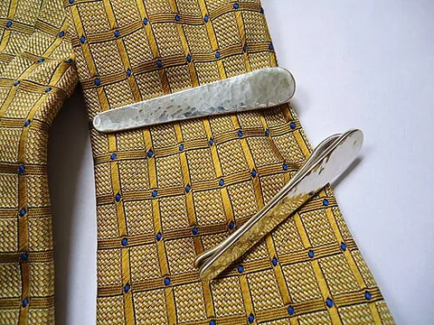 tie clip: a clip used to fasten the front and back parts of a tie