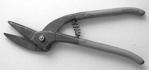 tin snips: large, heavily-constructed scissors or shears, operated by hand and used for cutting sheets of metal
