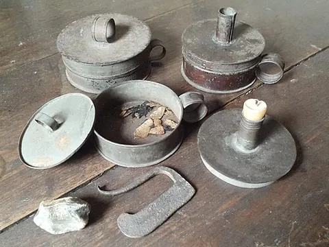 tinderbox: a small container containing flint, steel, and tinder (dry, finely-divided fibrous matter), once...