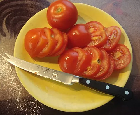 tomato knife: a small serrated kitchen knife designed to slice through tomatoes
