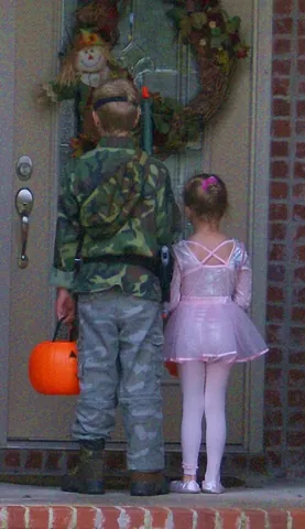 trick-or-treat: to go door-to-door requesting candy on Halloween night while wearing a costume