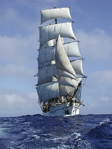 under sail: with sails unfurled; powered by the wind